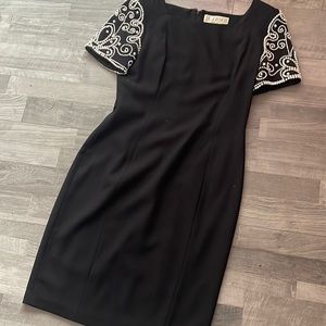 Black dress by A.J Bari size eight with pearls on the sleeves. Elegant